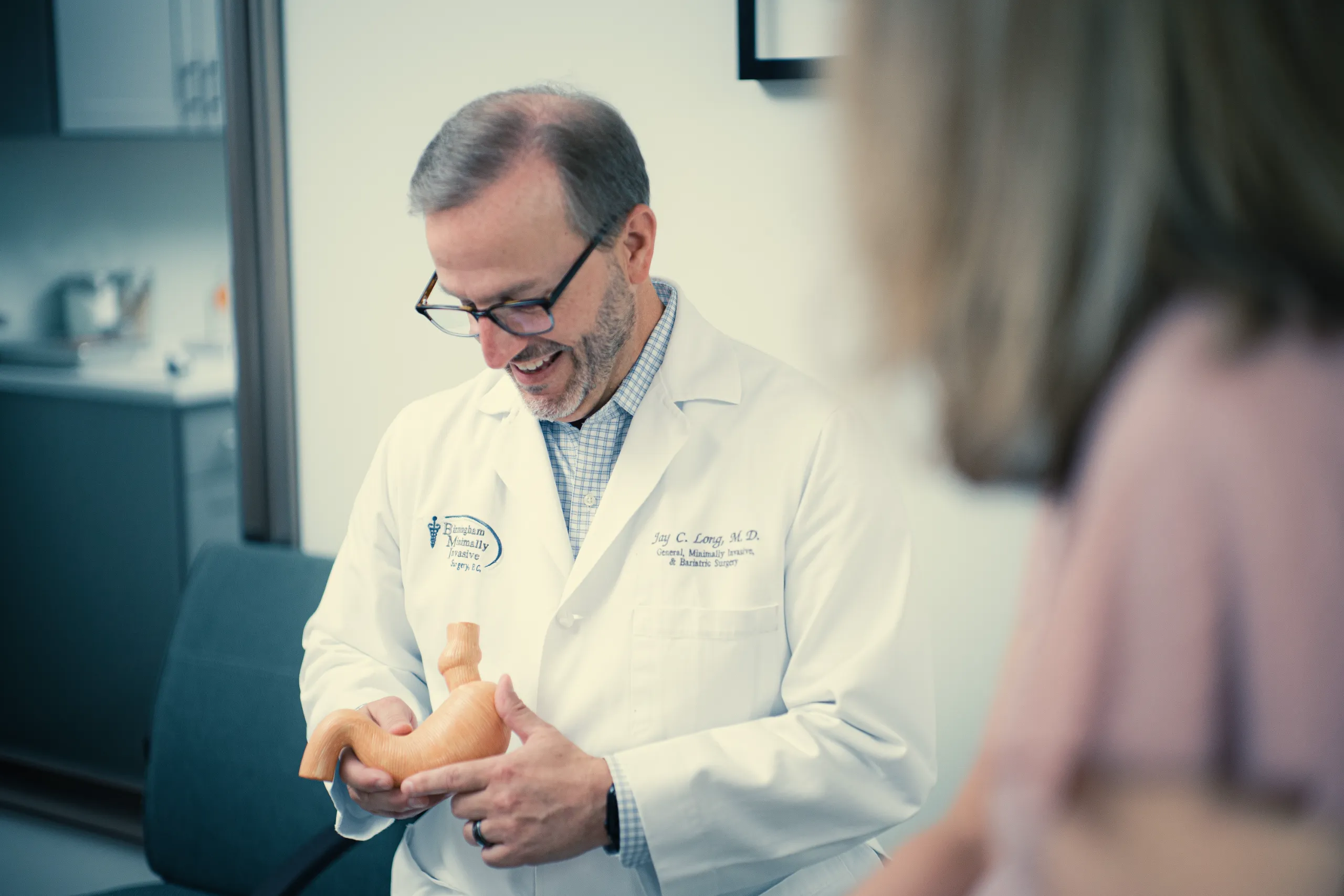 Doctor in white coat demonstrating stomach model to a patient in clinic during consultation