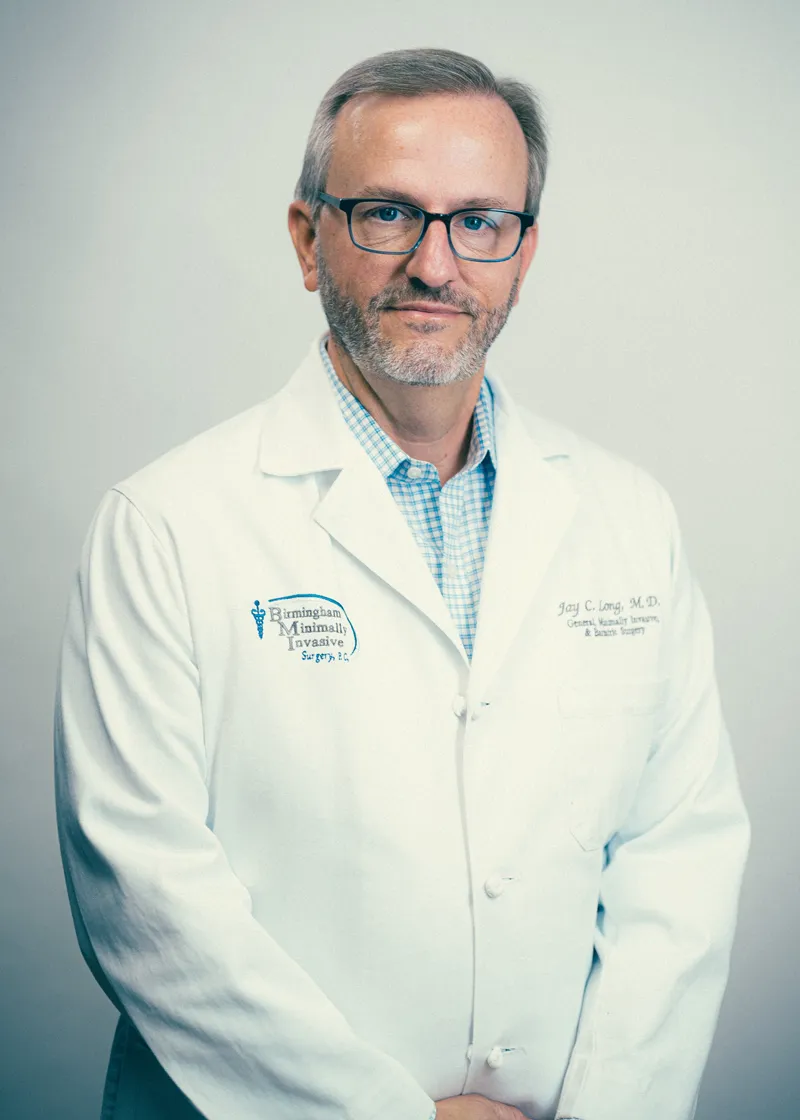 Portrait of a man doctor wearing glasses and a white lab coat, medical professional against a neutral background