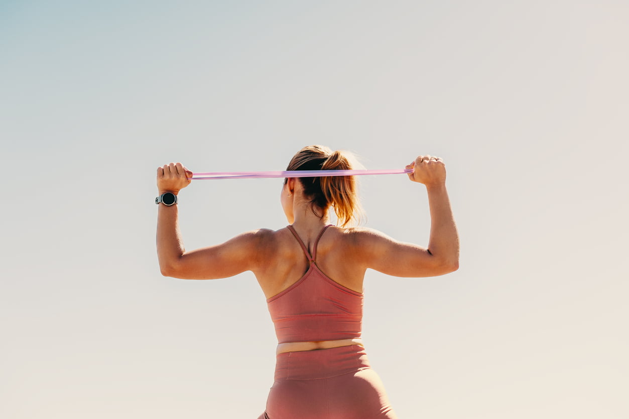 female athlete working out with resistance bands outdoors.